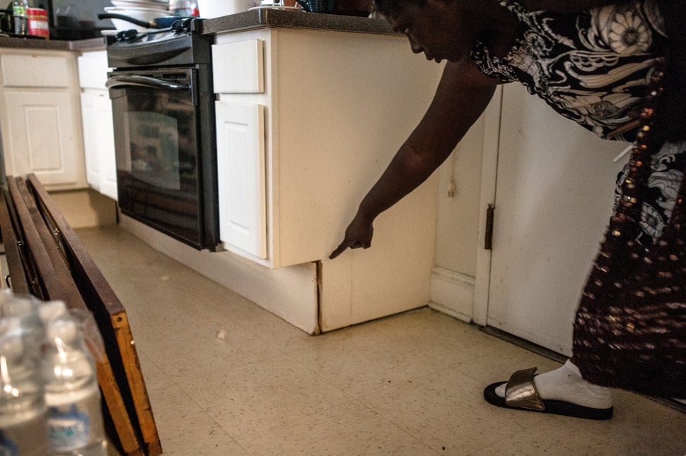 Latonia Bowser indicates the level where water rose in her apartment.