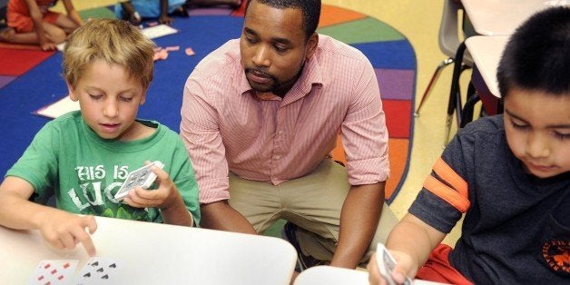 David Wise, center, works with Zachary Fiorenza, left, and Raul Saldana-Hernandez in their second grade summer school math class July 25, 2014 in Baltimore, Md. Wise is part of the Urban Teacher Program, and is a new teacher who spent a year as a resident teacher at Holabird Academy. (Barbara Haddock Taylor/Baltimore Sun/MCT via Getty Images)