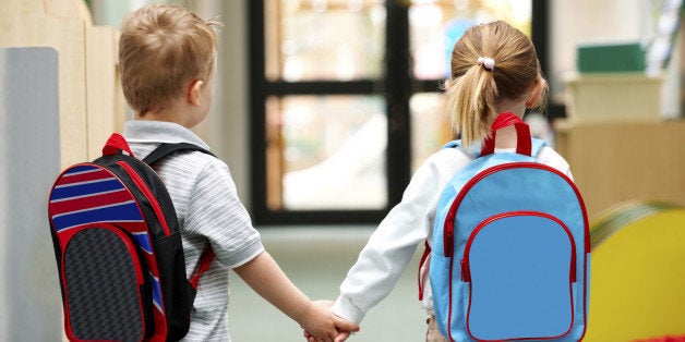 Two cute little children walking to school - Rear view