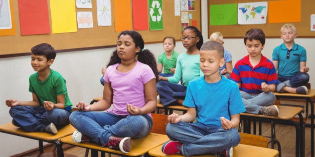 Pupils meditating on classroom desks at the elementary school