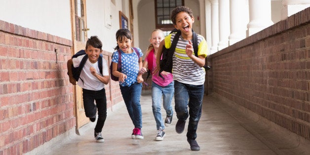 Cute pupils running down the hall at the elementary school