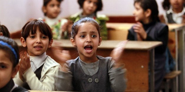 Yemeni girls clap their hands on their fist day of school at a public institution in the Yemeni capital Sanaa on November 1,