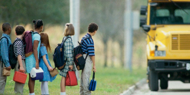 Side profile of students standing in line for a school bus