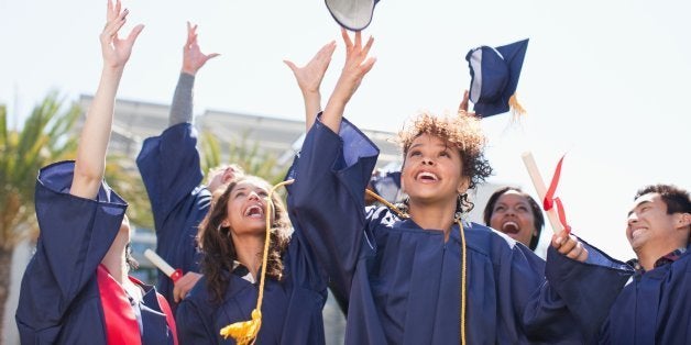 Graduates tossing caps into the air