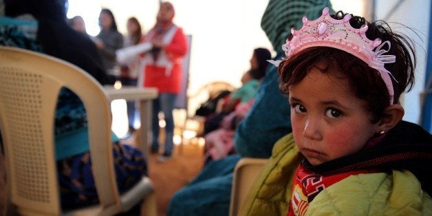 TO GO WITH AFP STORY BY SARA HUSSEIN
A child sits under a tent with Syrian refugee women attending a class on family plannin