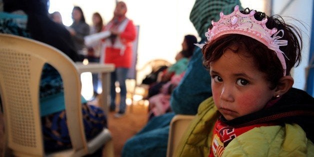 TO GO WITH AFP STORY BY SARA HUSSEINA child sits under a tent with Syrian refugee women attending a class on family planning organised by Doctors Without Borders (MSF) at a makeshift camp by Taybeh village, in Lebanon's eastern Bekaa Valley, on November 15, 2015. AFP PHOTO / JOSEPH EID (Photo credit should read JOSEPH EID/AFP/Getty Images)