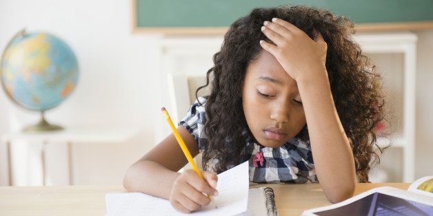 Frustrated mixed race student working in classroom