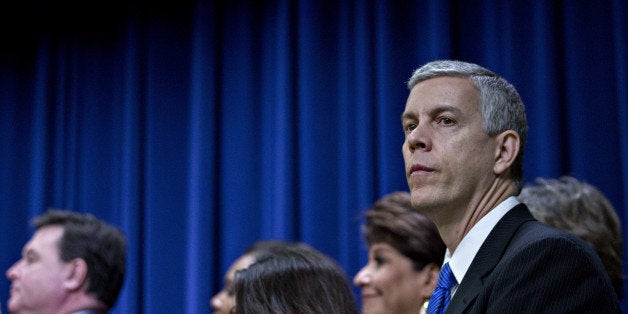 Arne Duncan, U.S. secretary of education, right, listens as U.S. President Barack Obama, not pictured, speaks before signing