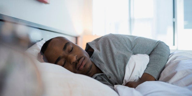 Serene man sleeping in bed in the morning