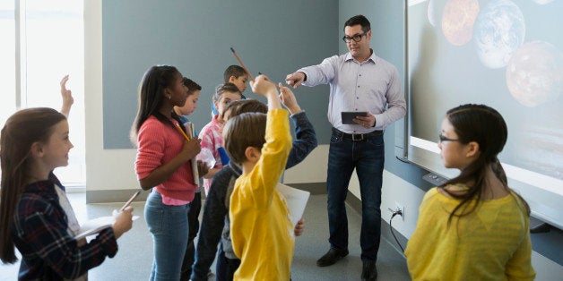 Students asking questions of teacher leading astronomy lesson