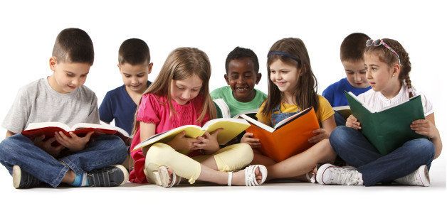 Group of happy multiracial school children reading books. Isolated on white background.