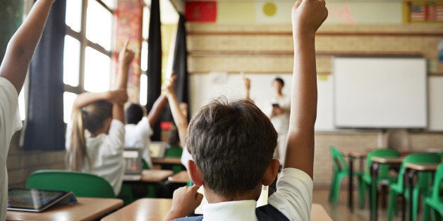 School children in uniforms in class with tablets