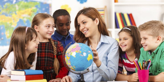 Teacher and children looking at globe