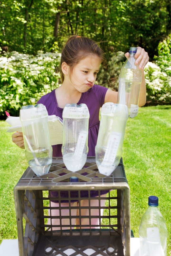 Young girl works on her Science Fair project - making a face as she checks temperature