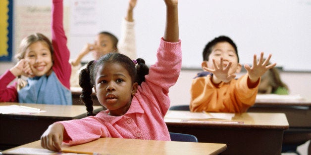 School children raising their hands in class