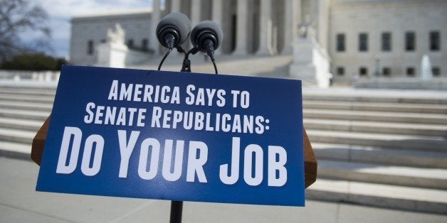 A sign calling on the Republicans in the Senate to hold confirmation hearings for Supreme Court Nominee Merrick Garland prior to a press conference by Senate Democrats outside the Supreme Court in Washington, DC, March 17, 2016. / AFP / SAUL LOEB (Photo credit should read SAUL LOEB/AFP/Getty Images)