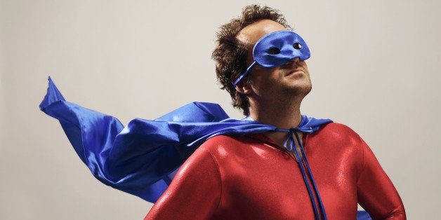 Man wearing superhero costume, looking up