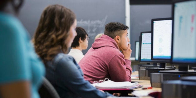 College students studying at computers in classroom