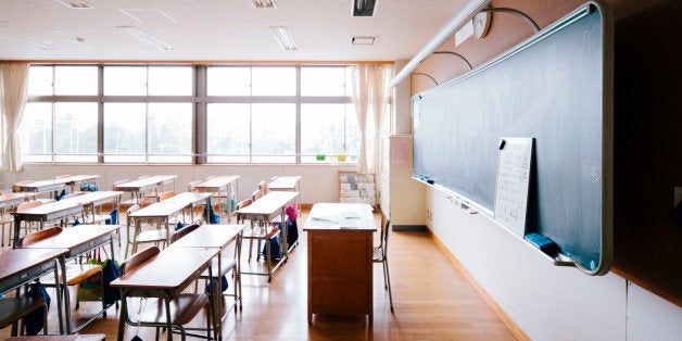 A view of a Japanese school classroom, traditional wooden desks and chairs, and blackboard. Interior shot, nobody, horizontal