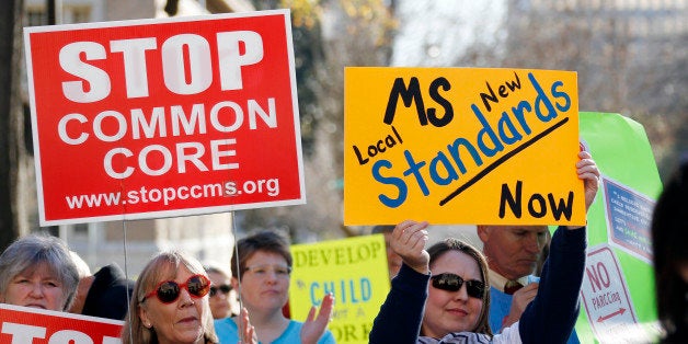 Common Core opponents wave signs and cheer at a rally opposing Mississippi's continued use of the Common Core academic standards on the steps of the Capitol in Jackson, Miss., Tuesday, Jan. 6, 2015. Both Gov. Phil Bryant and Lt. Gov. Tate Reeves have vowed that the state will quit using the standards. (AP Photo/Rogelio V. Solis)