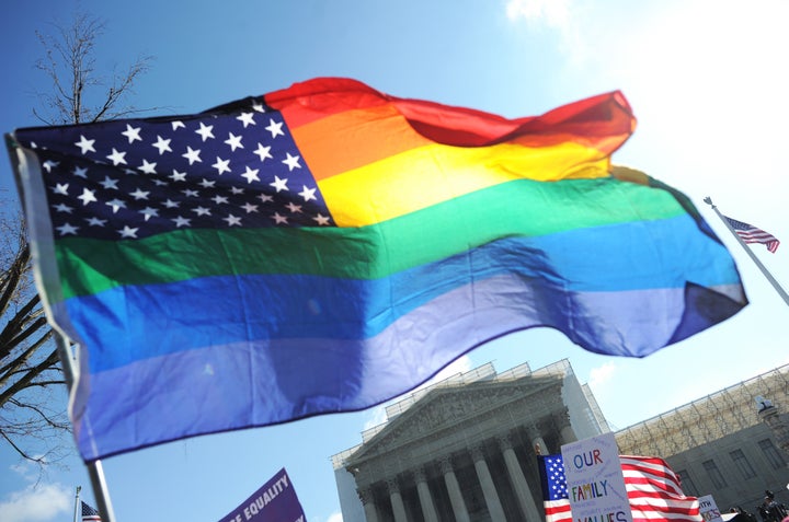 Same-sex marriage supporters wave a rainbow flag in front of the US Supreme Court on March 26, 2013 in Washington, DC. The US Supreme Court on Tuesday takes up the emotionally charged issue of gay marriage as it considers arguments that it should make history and extend equal rights to same-sex couples. Waving US and rainbow flags, hundreds of gay marriage supporters braved the cold to rally outside the court along with a smaller group of opponents, some pushing strollers. Some slept outside in hopes of witnessing the historic hearing. AFP PHOTO/Jewel Samad (Photo credit should read JEWEL SAMAD/AFP/Getty Images)