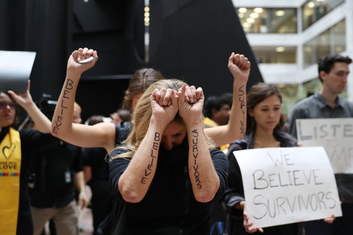 Protesters display notes written on their arms reading "Believe Survivors" while demonstrating ahead of a Senate Judiciary Co