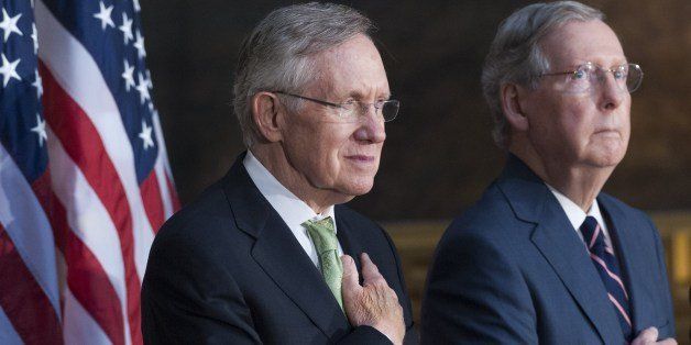 Senate Republican Leader Mitch McConnell (R) and Senate Majority Leader Harry Reid (L) stand during the National Anthem during a ceremony to posthumously present a Congressional Gold Medal to Raoul Wallenberg at the US Capitol in Washington, DC, July 9, 2014. Wallenberg, a Swedish diplomat, saved the lives of nearly 100,000 Hungarian Jews during the Holocaust. AFP PHOTO / Saul LOEB (Photo credit should read SAUL LOEB/AFP/Getty Images)