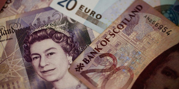 A Bank of Scotland Plc pound sterling banknote, right, sits with a Bank of England 20 pound sterling banknote and a 20 euro banknote in this arranged photograph taken inside a Travelex store, operated by Travelex Holdings Ltd., in Glasgow, U.K., on Tuesday, Sept. 16, 2014. The pound dropped 0.4 percent to $1.6171 as of 10:22 a.m. in London, as Citigroup Inc. said in a note that the Scottish referendum will dominate the pound's 'price action' this week. Photographer: Simon Dawson/Bloomberg via Getty Images