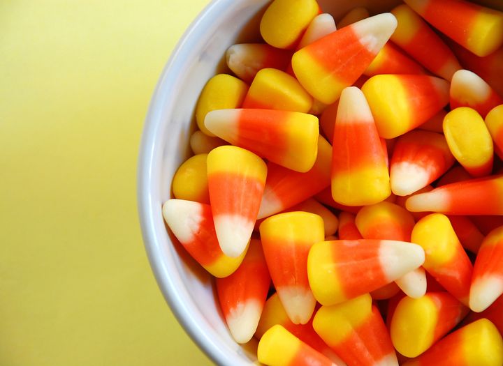 Dish of candy corn on yellow background