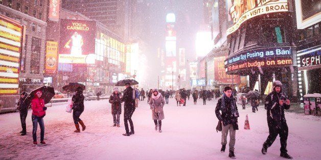 NEW YORK, NY - JANUARY 26: People walk down mostly empty streets following road closures in Times Square on January 26, 2015 in New York City. New York, and much of the Northeast, is bracing for a major winter storm which is expected to bring blizzard conditions and 10 to 30 inches of snow to the area. (Photo by Cem Ozdel/Anadolu Agency/Getty Images)
