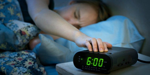 Canada, Ontario, Toronto, Teenage girl with hand on alarm clock