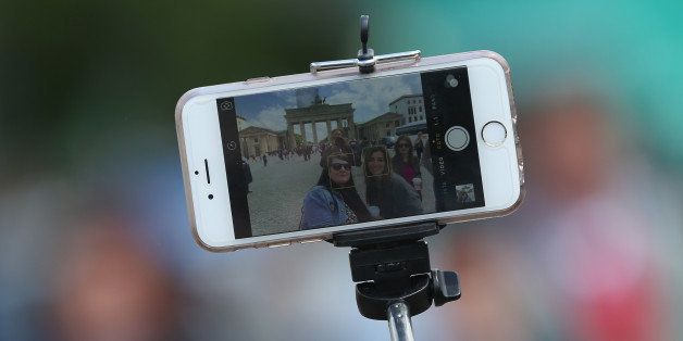 BERLIN, GERMANY - MAY 19: Tourists photograph themselves with a smartphone attached to a selfie stick at the Brandenburg Gate on May 19, 2015 in Berlin, Germany. Selfie sticks are becoming a common site across the globe and some museums and other tourist attractions have banned them. (Photo by Sean Gallup/Getty Images)