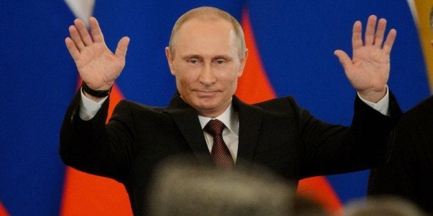 Russia's President Vladimir Putin gestures after signing a treaty on the Ukrainian Black Sea Crimea peninsula becoming part o
