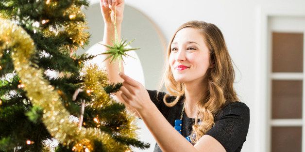 Young woman decorating Christmas tree