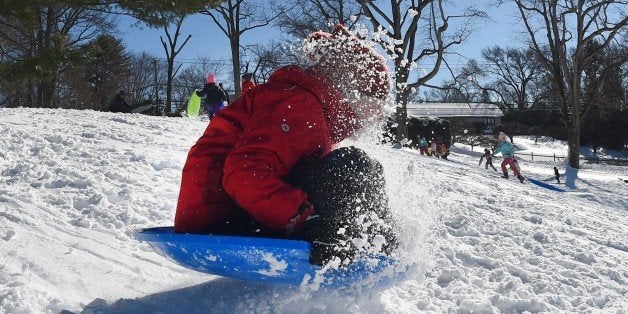 A child goes sledding down a hill in Greenwich, Connecticut January 24, 2016.Millions of people in the eastern United States started digging out Sunday from a huge blizzard that brought New York and Washington to a standstill, but the travel woes were far from over. The storm -- dubbed 'Snowzilla' -- killed at least 18 people after it walloped several states over 36 hours on Friday and Saturday, affecting an estimated 85 million residents who were told to stay off the roads and hunker down in doors for their own safety. / AFP / Timothy A. CLARY (Photo credit should read TIMOTHY A. CLARY/AFP/Getty Images)