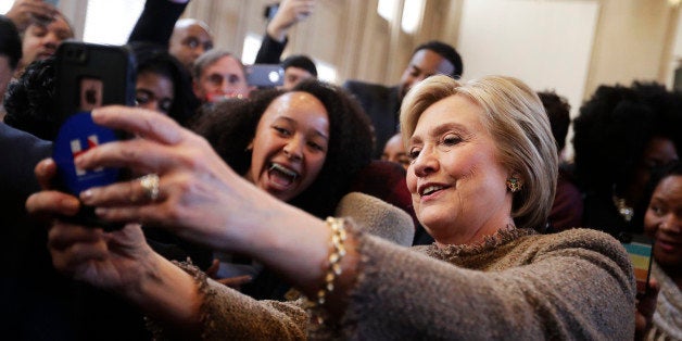 Democratic presidential candidate, Hillary Clinton, center, takes a selfie with an audience member's phone as she greets the