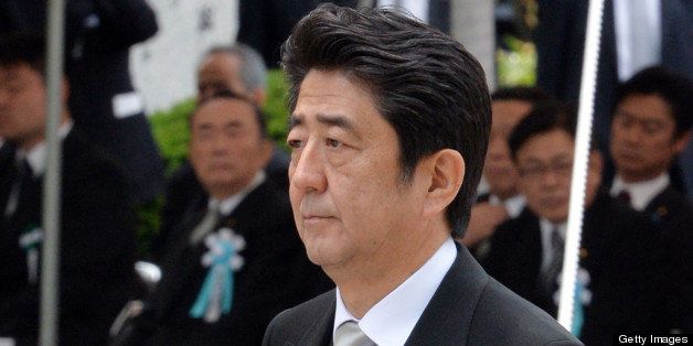 Japanese Prime Minister Shinzo Abe offers a chrysanthemum during an annual memorial service at Tokyo's Chidorigafuchi National Cemetery, the tomb for unknown war victims, on May 27, 2013. The remains of 1,628 unknown soldiers who died during World War II in Russia and Iwojima-island were buried in the cemetery. AFP PHOTO / Yoshikazu TSUNO (Photo credit should read YOSHIKAZU TSUNO/AFP/Getty Images)