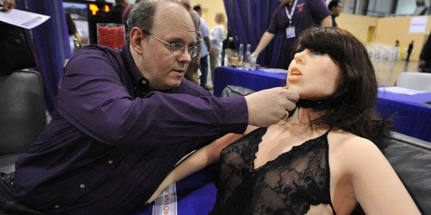 Engineer-inventor Douglas Hines adjusts the head of his company's 'True Companion' sex robot, Roxxxy, at the TrueCompanion.com booth at the AVN Adult Entertainment Expo in Las Vegas, Nevada, January 9, 2010. In what is billed as a world first, a life-size robotic girlfriend complete with artificial intelligence and flesh-like synthetic skin was introduced to adoring fans at the AVN Adult Entertainment Expo. AFP PHOTO / Robyn Beck (Photo credit should read ROBYN BECK/AFP/Getty Images)