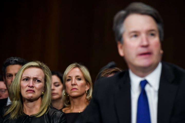 Family friend Laura Cox Kaplan, left, tears up while seated behind Brett Kavanaugh during Thursday's testimony before the Sen