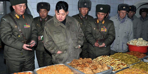 In this undated photo released by the Korean Central News Agency and distributed in Tokyo by the Korea News Service on Thursday, Jan. 19, 2012, North Korean leader Kim Jong Un, center, looks at food items at an undisclosed location in North Korea. KCNA reported he was inspecting a military unit. (AP Photo/Korean Central News Agency via Korea News Service) JAPAN OUT UNTIL 14 DAYS AFTER THE DAY OF TRANSMISSION