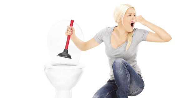 Woman unclogs a stinky toilet with plunger isolated on white background