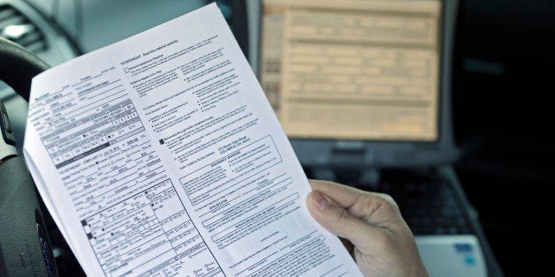 In this Wednesday, Jan. 28, 2015 photo, Ohio State Highway Patrol Lt. Antonio Matos holds a test ticket from the new electronic citation system inside a patrol car at the Cleveland Metro Post in Brook Park, Ohio. The e-ticketing process reduces errors, save time and makes the paperwork easier to read and want to take it a step further by arranging for citations to be electronically transmitted to local courts instead of being hand-delivered on paper.(AP Photo/Mark Duncan)