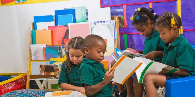 Four preschool kids reading in classroom