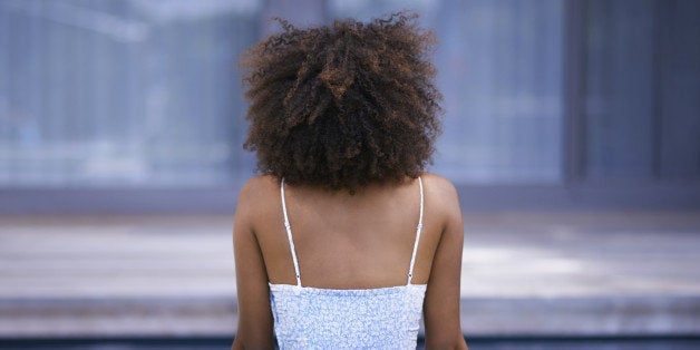 Rear view shot of a young woman relaxing by the pool