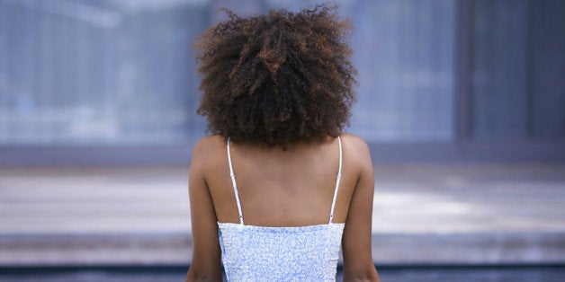 Rear view shot of a young woman relaxing by the pool