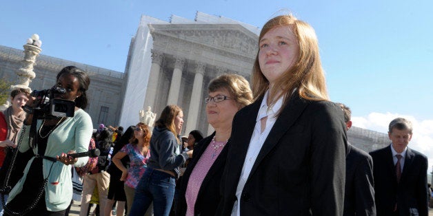 Abigail Fisher, right, who sued the University of Texas, walks outside the Supreme Court in Washington, Wednesday, Oct. 10, 2