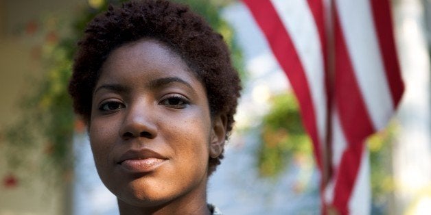 Portrait of a African American Soldier in Uniform with flag in background.