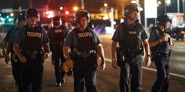 Police deployed during a civil disobedience action on August 10, 2015 on West Florissant Avenue in Ferguson, Missouri. The night ended with over 10 arrests for disorderly conduct. St. Louis County declared a state of emergency Monday following a night of unrest in Ferguson, after a teenager was charged with shooting at police officers. The order was issued as an 18-year-old was charged in connection with a shootout in Ferguson August 9th after a day of peaceful protests marking the first anniversary of the police shooting of unarmed black teenager Michael Brown. AFP PHOTO / MICHAEL B. THOMAS (Photo credit should read Michael B. Thomas/AFP/Getty Images)