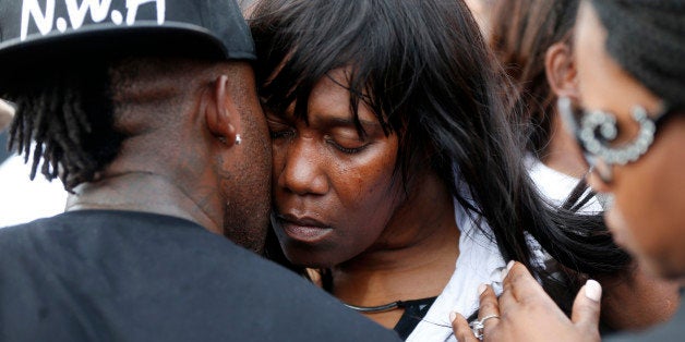 Sandra Sterling, aunt of Alton Sterling, is comforted at a vigil outside the Triple S convenience store in Baton Rouge, La., Wednesday, July 6, 2016. Sterling, 37, was shot and killed outside the store by Baton Rouge police, where he was selling CDs. (AP Photo/Gerald Herbert)