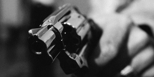 Hand holding gun, close-up, b&w